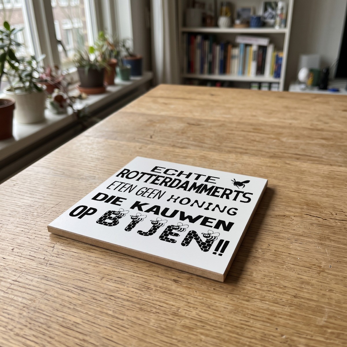 Rotterdamse quote wit 013, gedrukt op een houten onderzetter