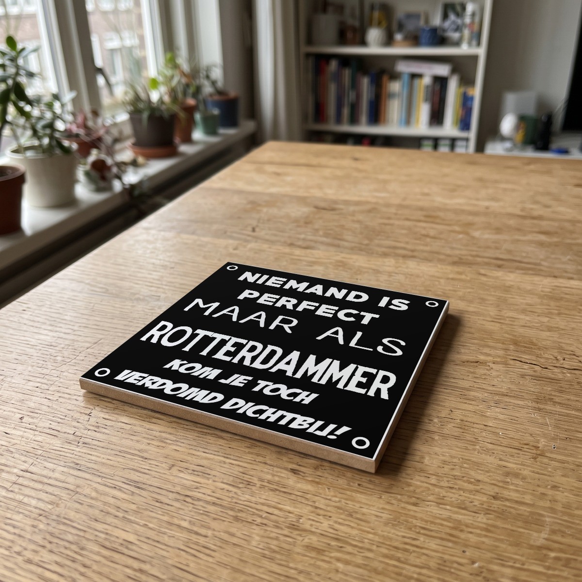 Rotterdamse quote zwart 003, gedrukt op een houten onderzetter